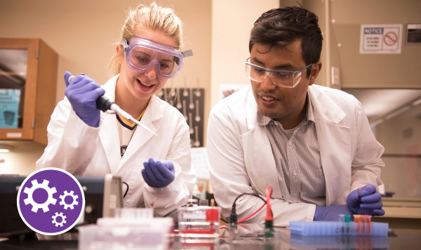 Two chemistry students preparing an experiment in a classroom